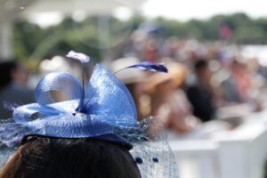 image of top of woman's head with blue fascinator and decorated table in background
