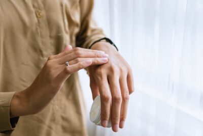 Image of woman gently touching her own hand.