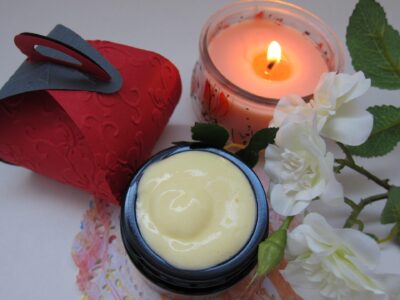 Image of colorful jars of cream and a lit candle