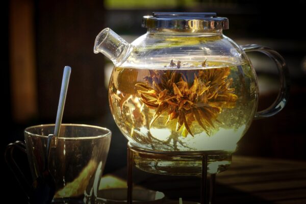 image of glass teapot with blooming leaves